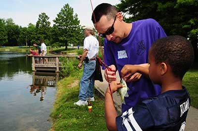 Man helping child with fishing