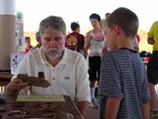 Dr. Rick Jones sharing information about archaeology with a young person.